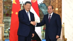 Xi Jinping shakes hands with Abdel Fattah el-Sisi in front of the Chinese and Egyptian flags in Cairo