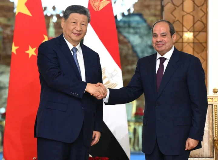Xi Jinping shakes hands with Abdel Fattah el-Sisi in front of the Chinese and Egyptian flags in Cairo